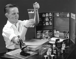 un gamin des années 50 joue avec son set de chimie.