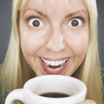 A woman sips from a coffee cup and smiles crazily into the fisheye lens