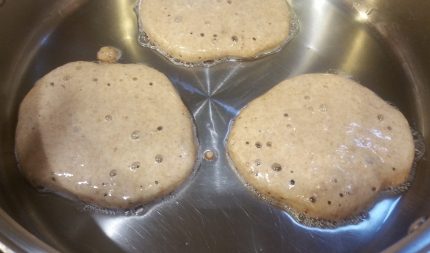 air bubbles are visible as pancakes cook on a hot pan